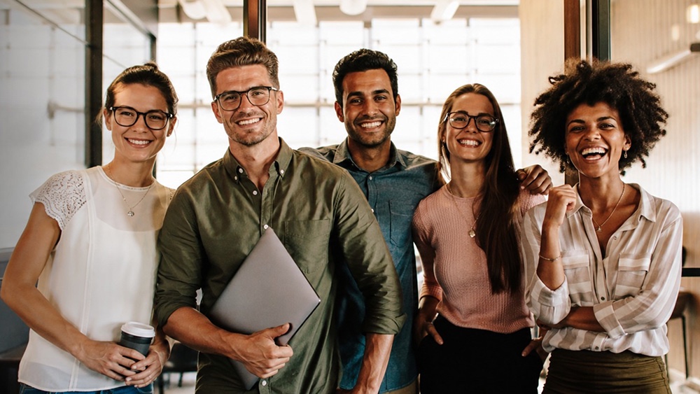 Five Isoclima US team members standing together and smiling in the office